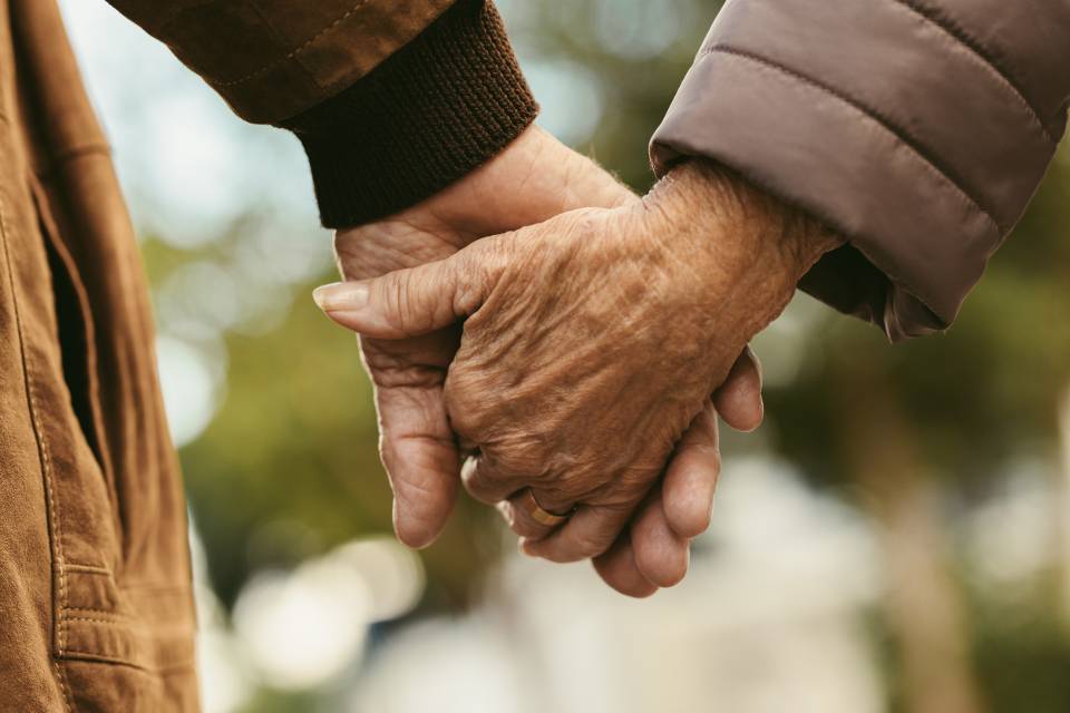 elderly couple holding hands stock