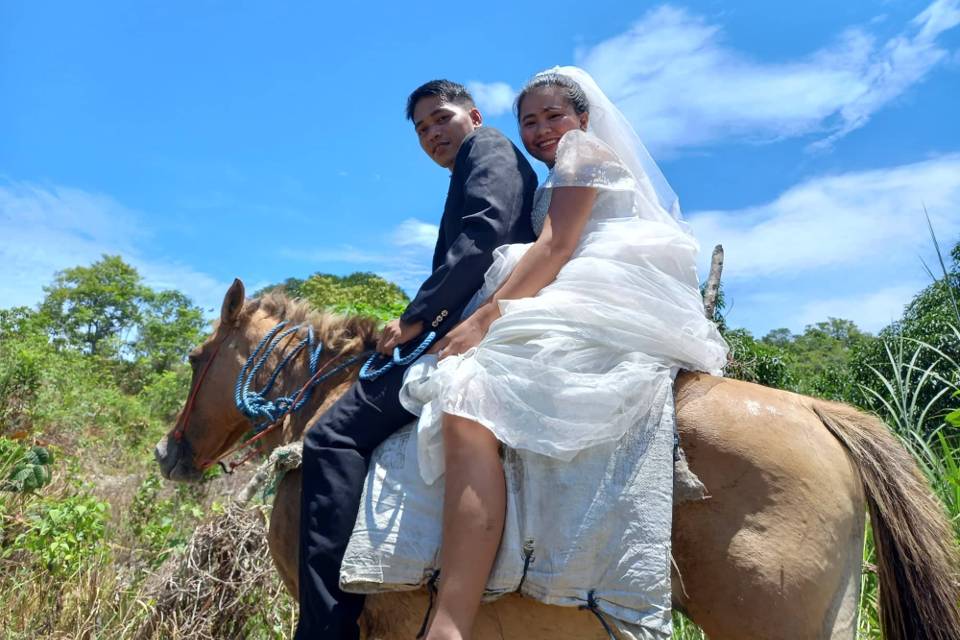 Engilyn and Brokcild Muñez riding a horse after wedding