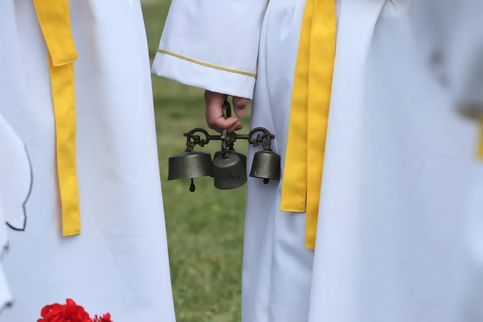 Stock photo of altar server sacristan carrying bells on Corpus Christi feast