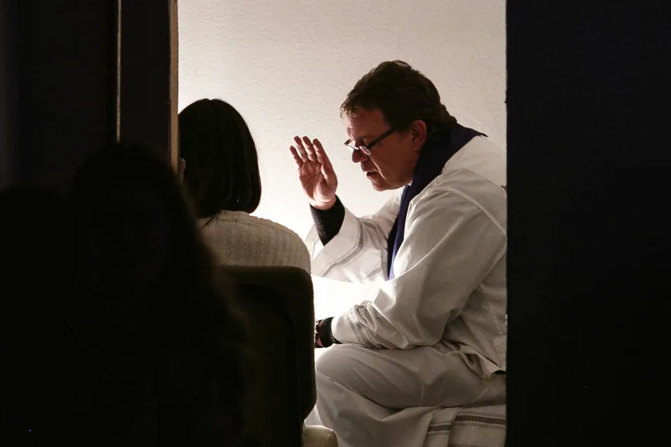 Stock photo of a priest hearing a confession by Josh Applegate on unsplash