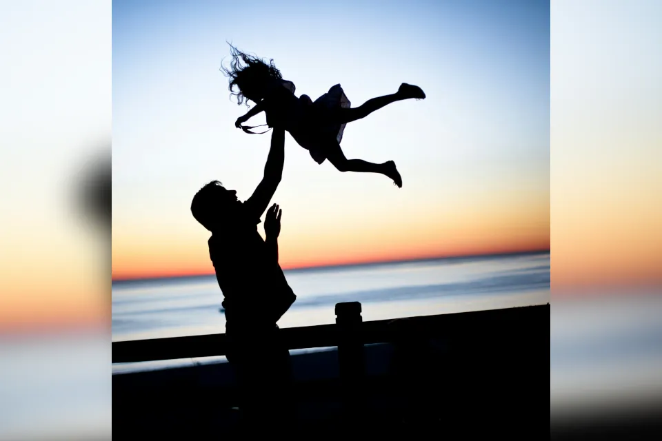 stock photo of father throwing daughter in air silhouette by Lauren Lulu Taylor on unsplash